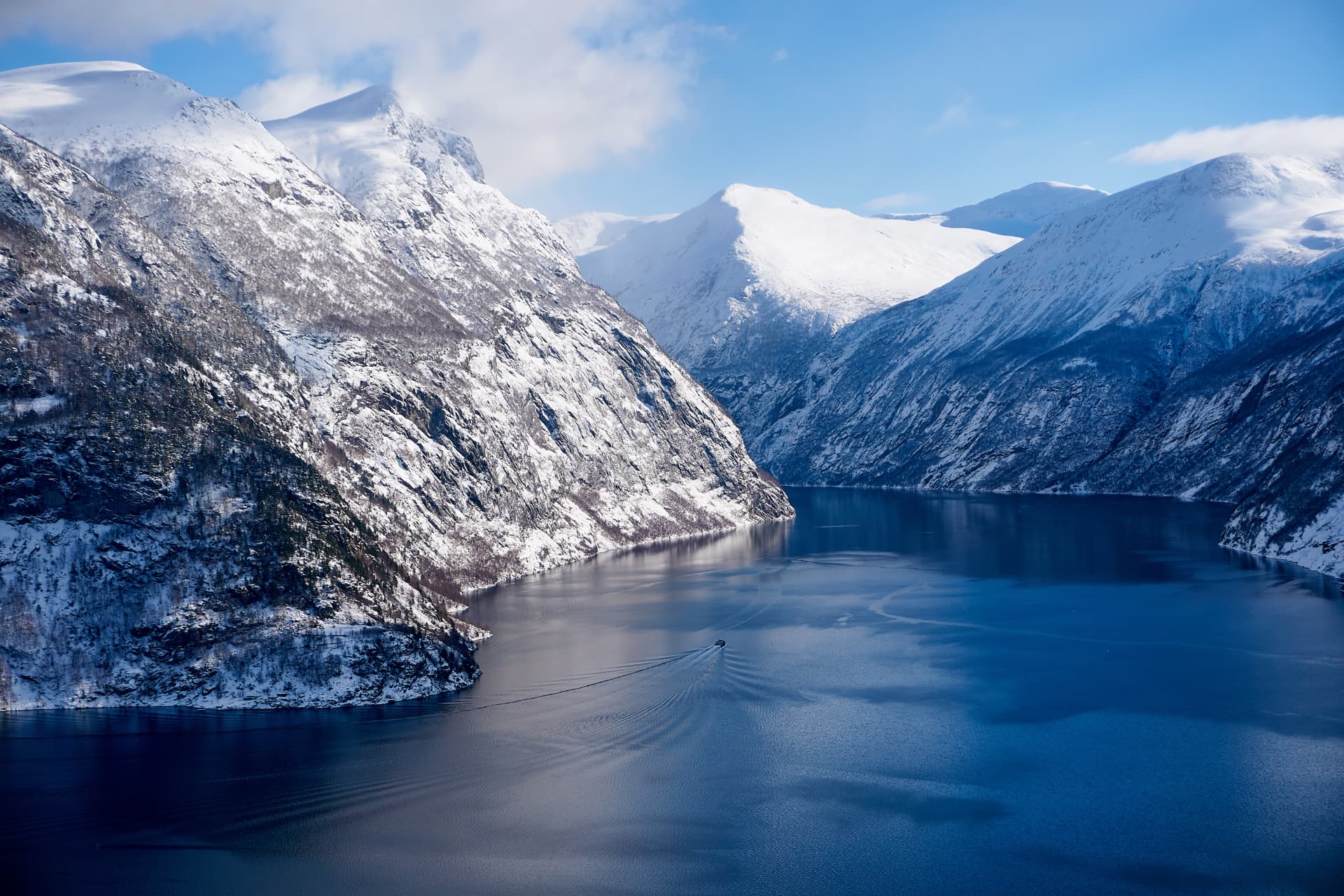 Snow-covered mountains above a deep Norwegian fjord