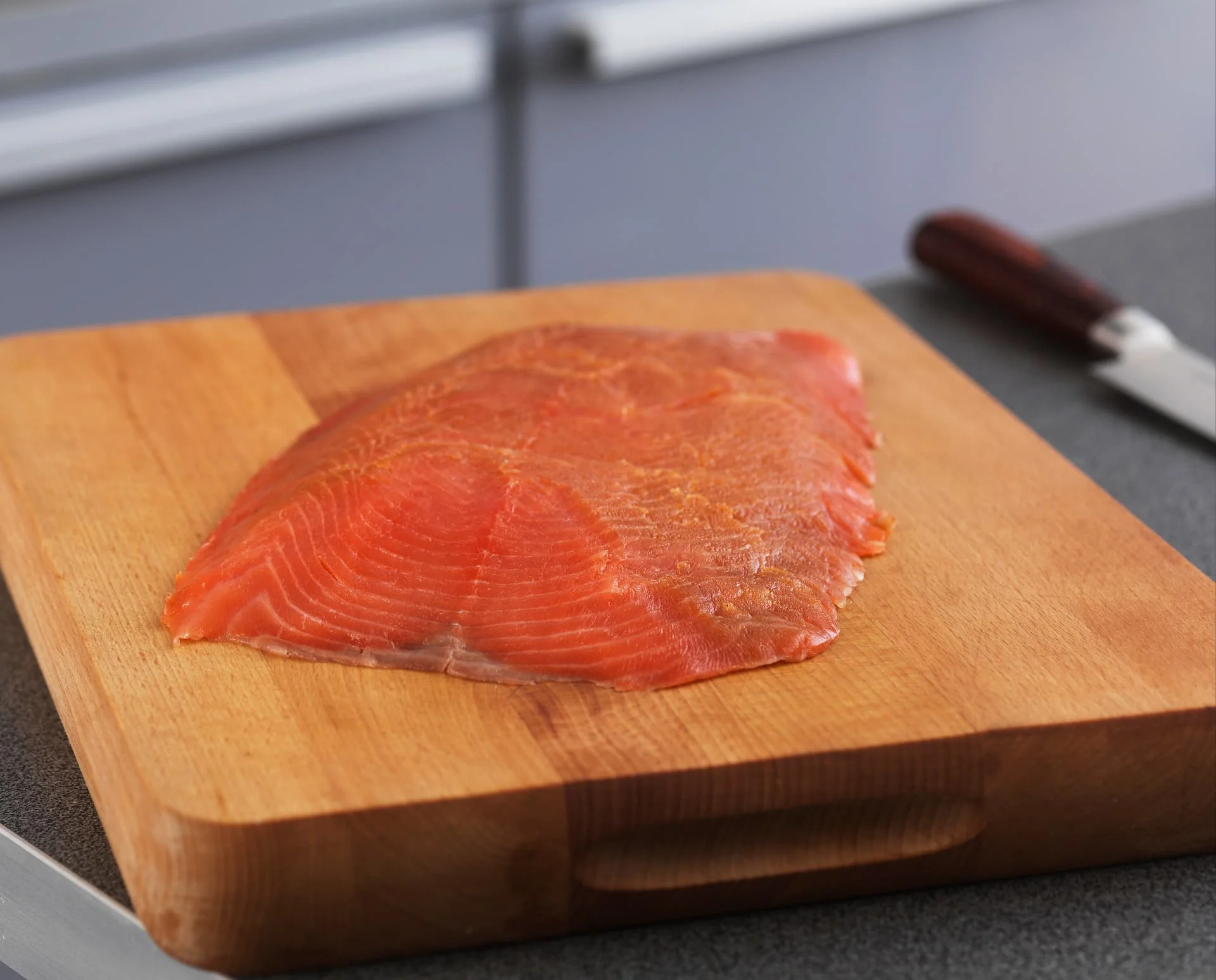 Łosoś wędzony (Salmo salar) — Otrymowany płat norweskiego łososia na desce do krojenia