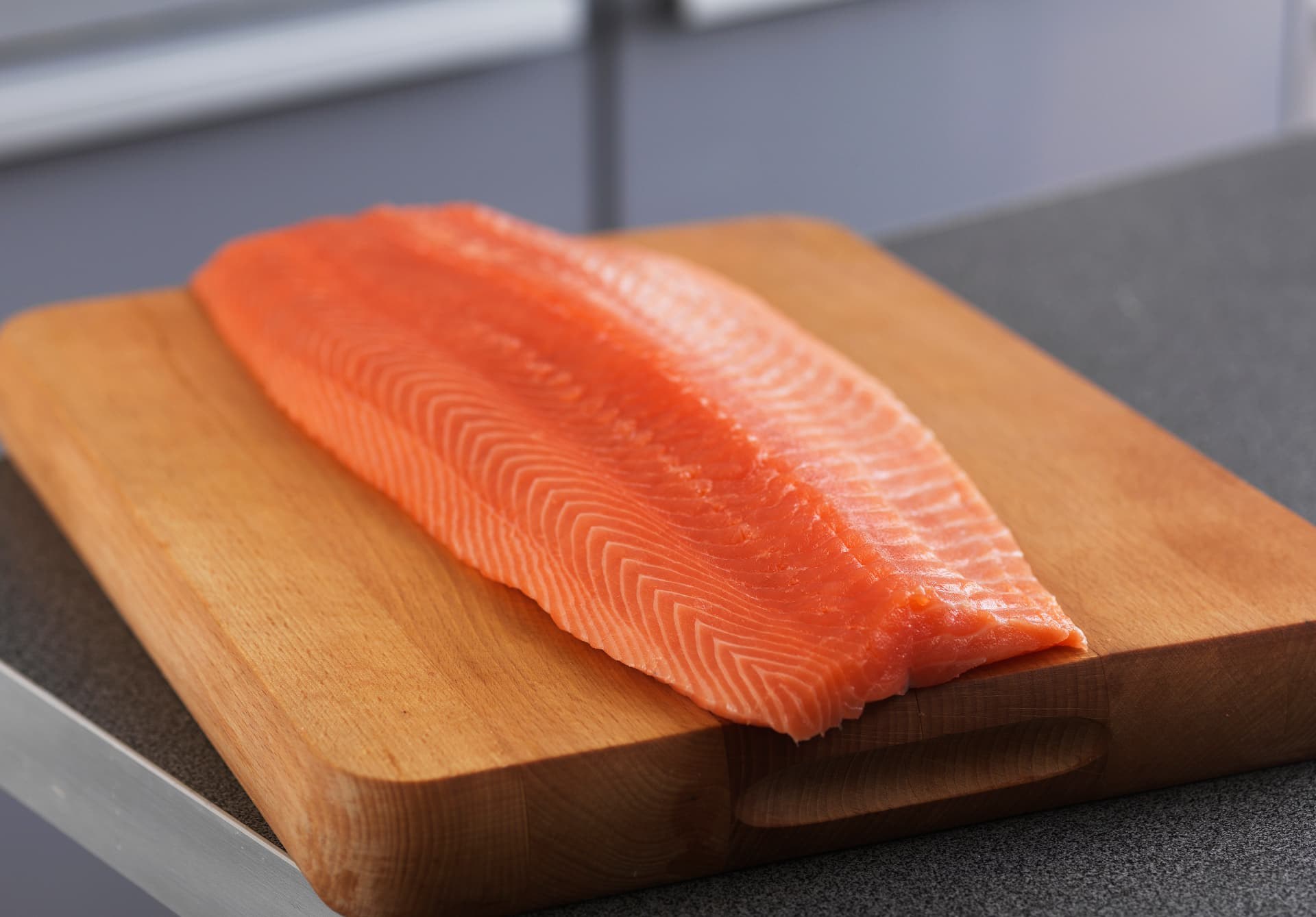 Finished Norwegian salmon fillet on a wooden board, showing its colour and muscle structure